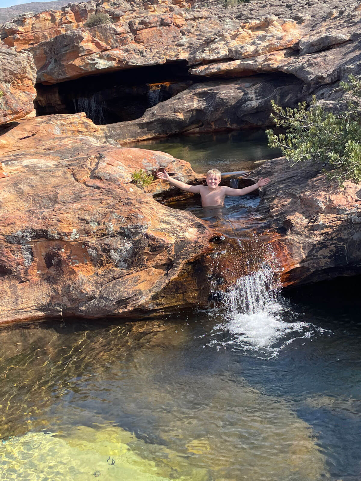 Young boy in natural rock pool